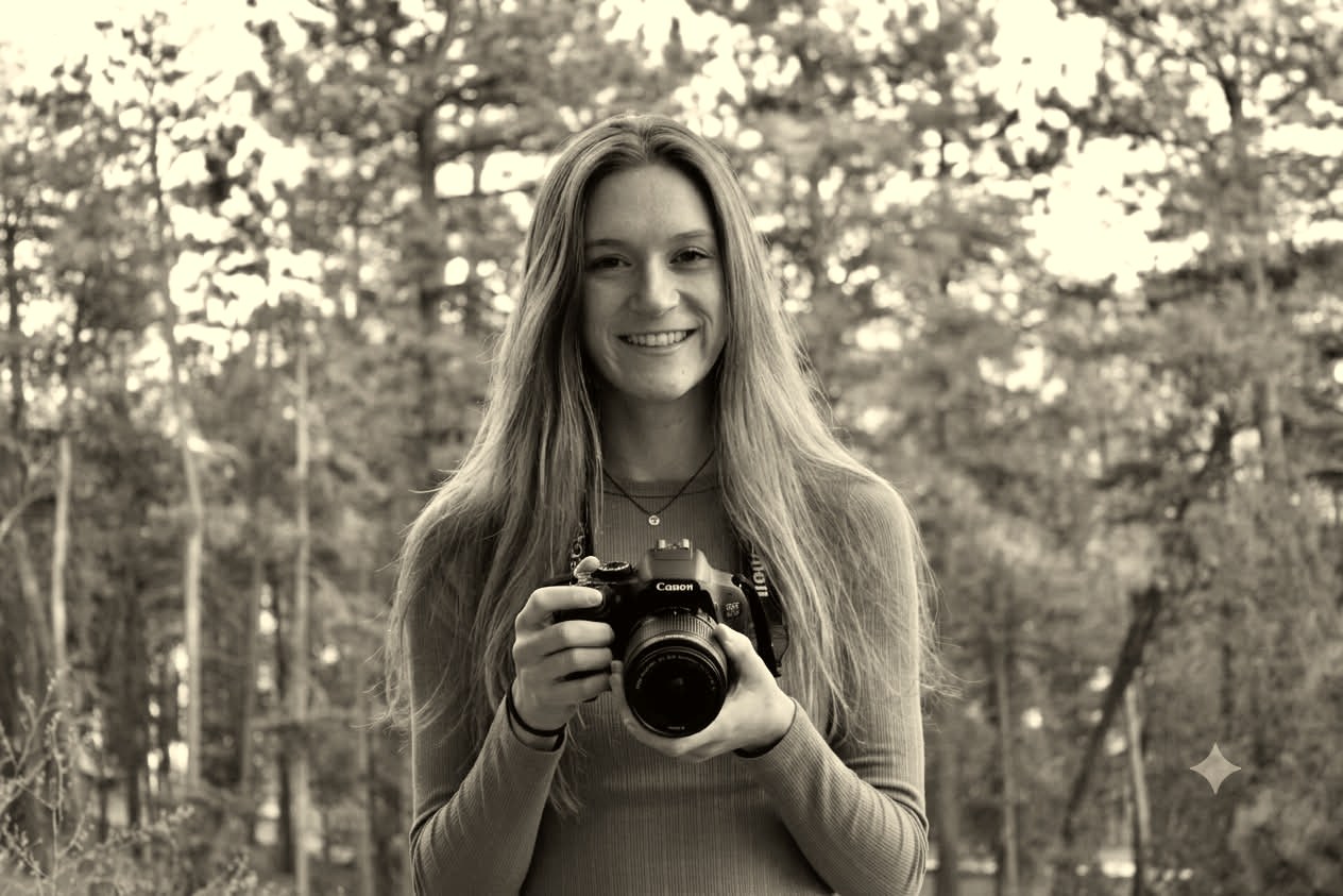 Jen, a Colorado photographer, holding her camera in the trees
