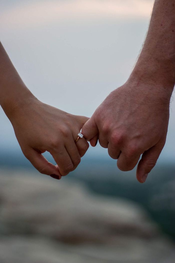 Holding pinkies with the engagement ring in view