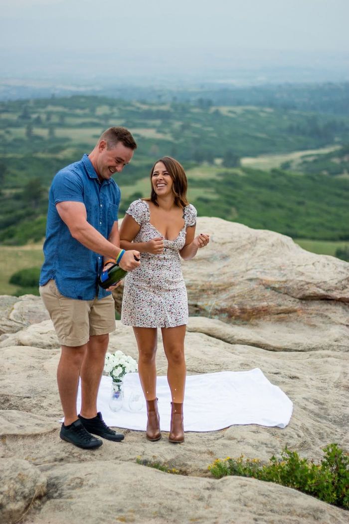 Popping champagne to celebrate the engagement on the overlook