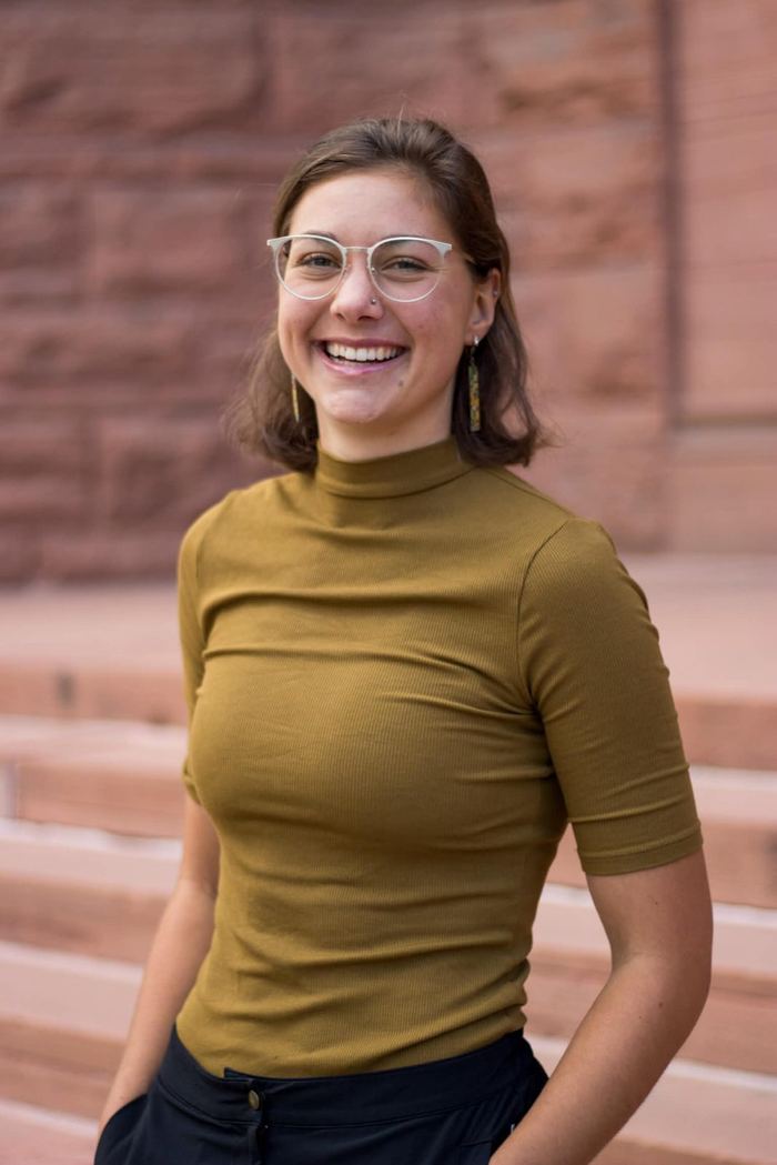Senior portrait on the red sandstone steps at Colorado College