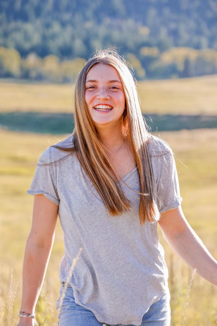 Senior walking through the golden meadow in Evergreen, Colorado