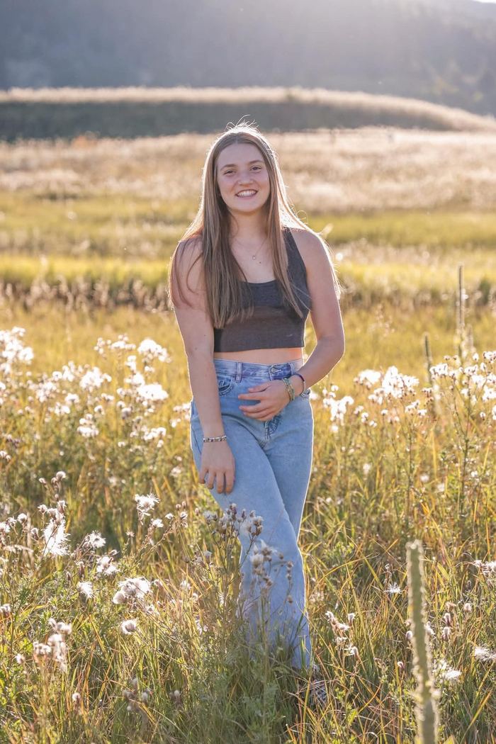 Senior standing in the wildflowers at Elk Meadow in Evergreen