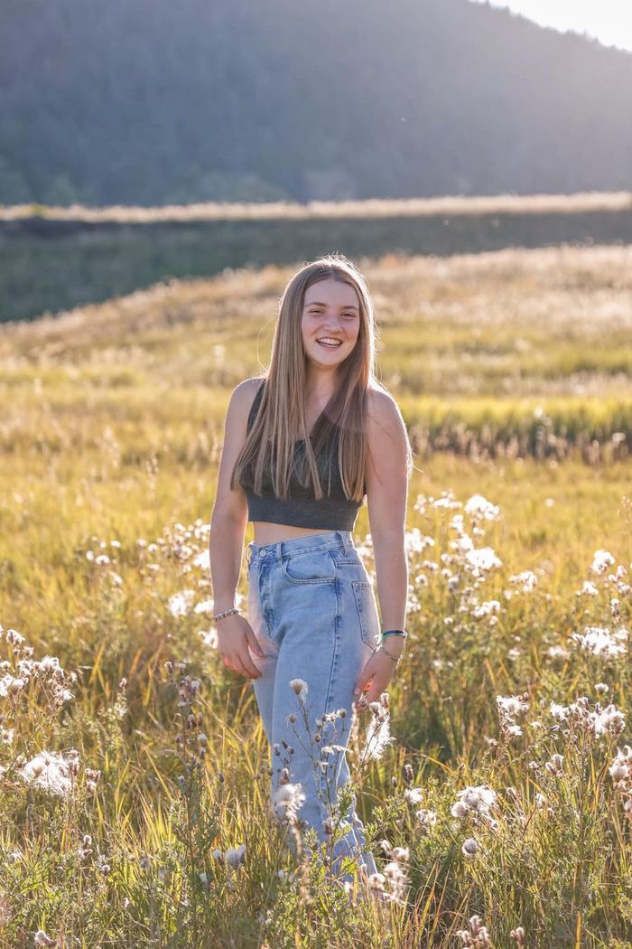 Full-length senior portrait in the wildflower meadow