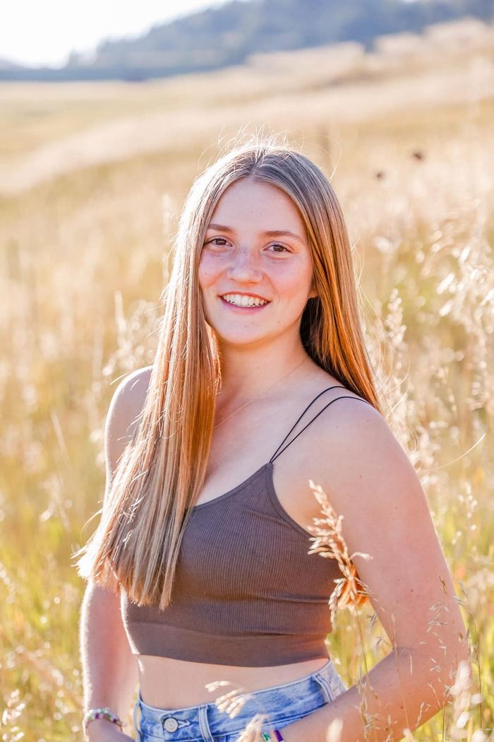 Golden hour senior portrait with the sun behind her hair