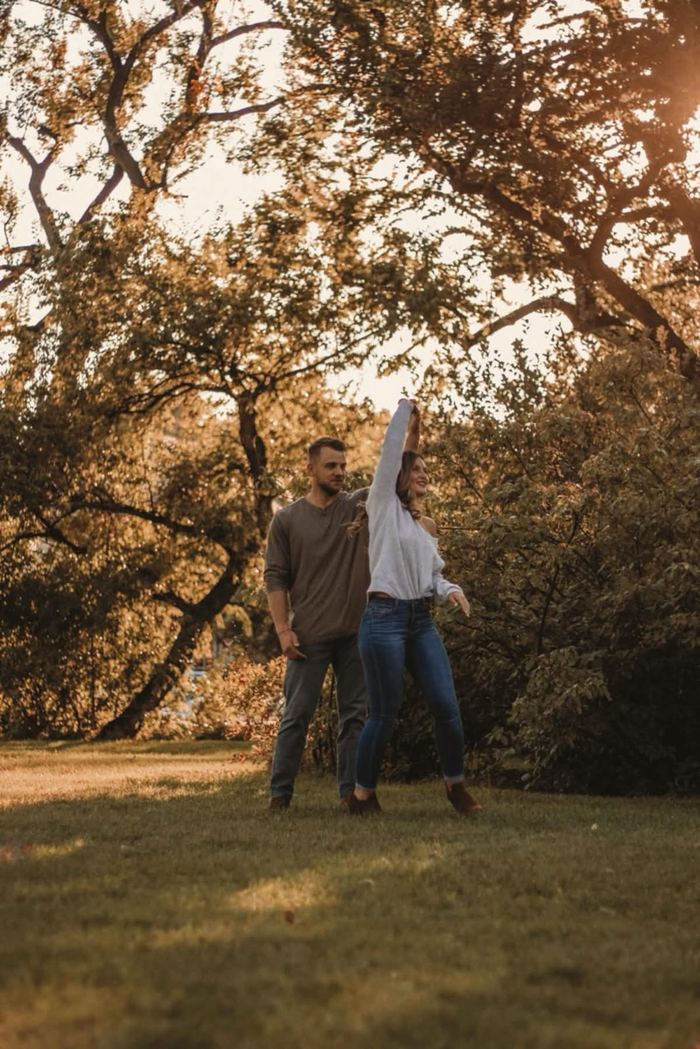 She twirls under his arm on the lawn under the big trees in Washington Park