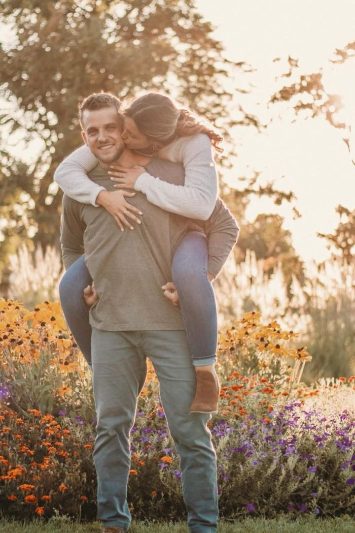 Piggyback ride in front of the orange and purple flower gardens at Wash Park