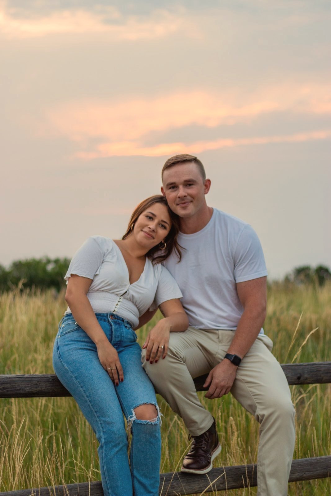 Engaged couple on a fence