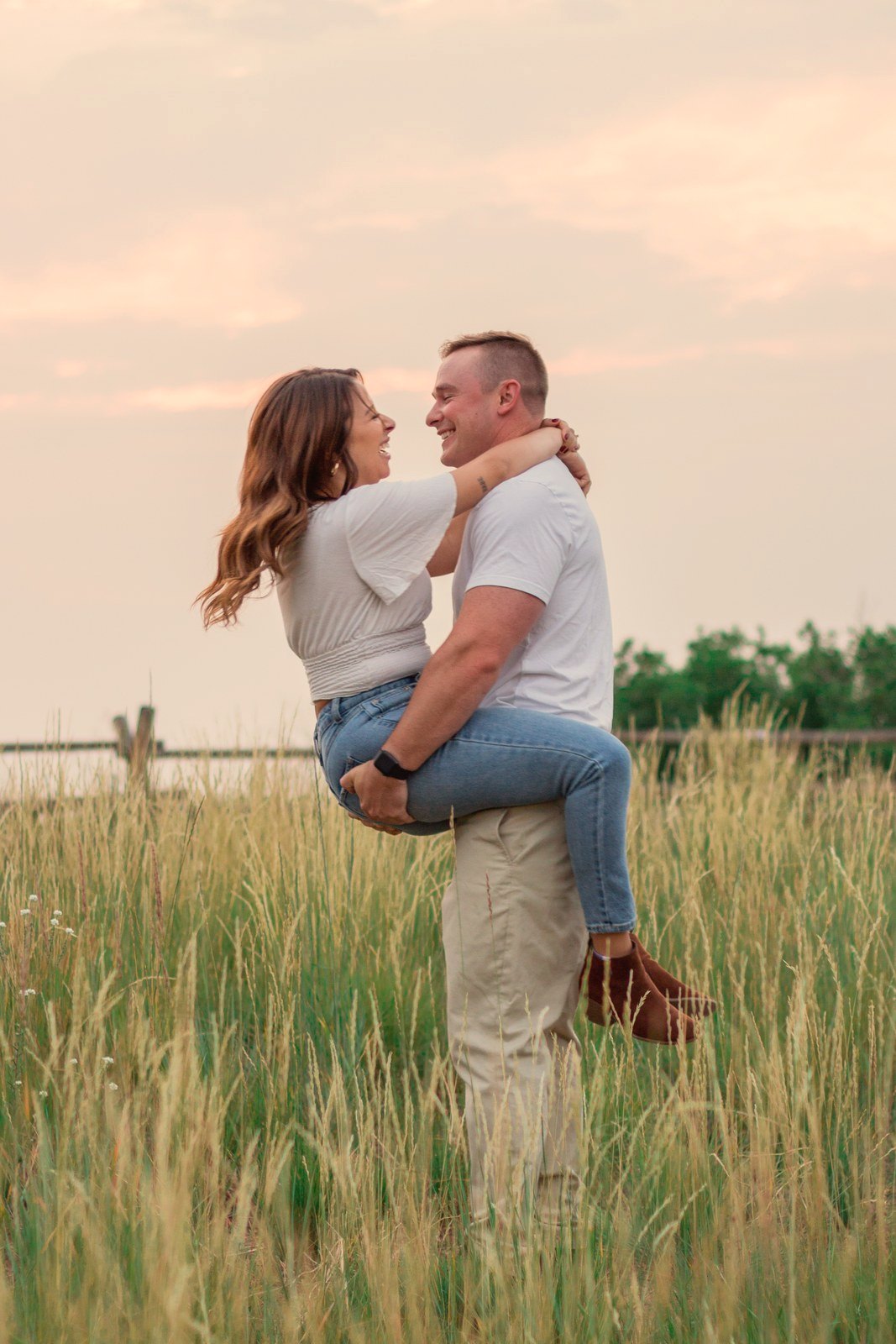 Couple embracing in a golden field at sunset