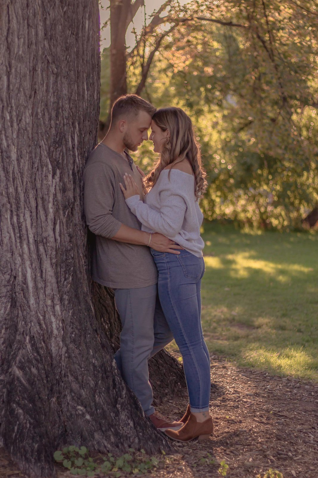 Couple by a tree with foreheads together
