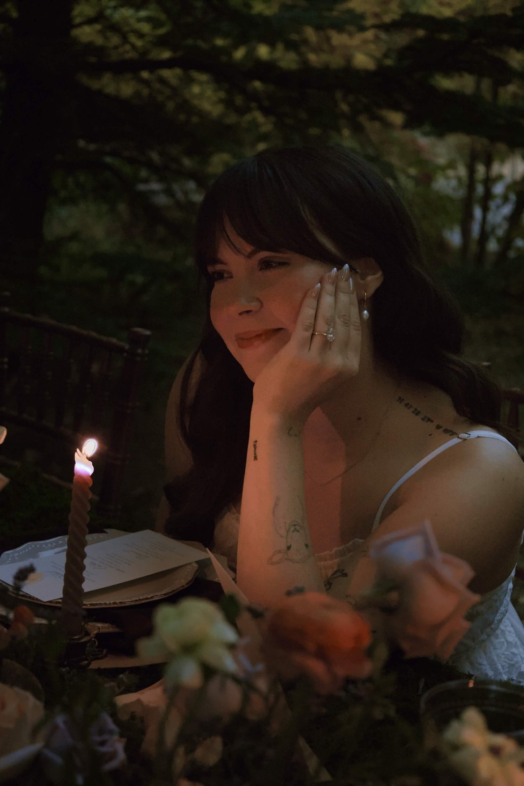 Smiling by candlelight at a flower-covered table