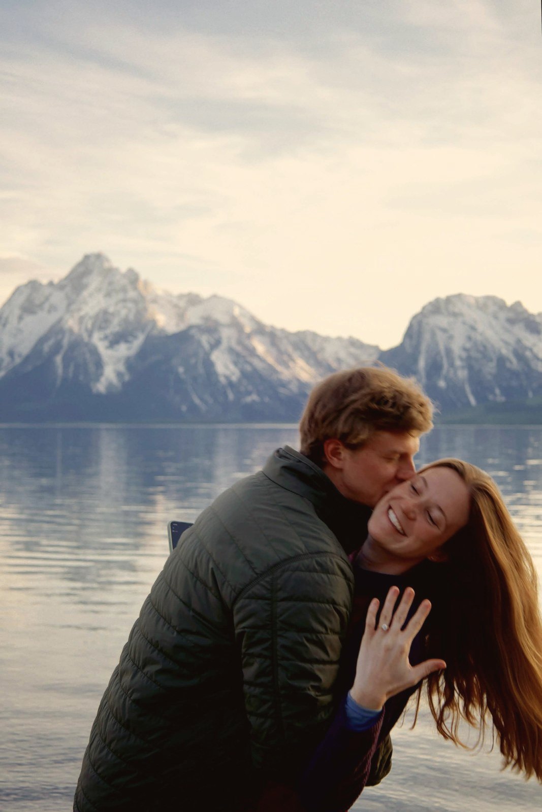 Couple at a Rocky Mountain lake with snowy peaks