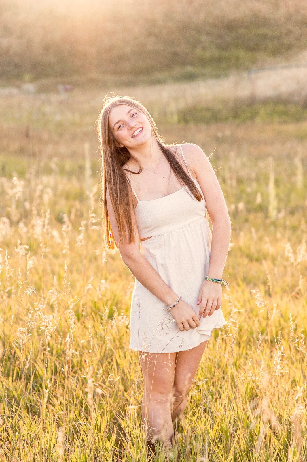 Senior portrait in a white dress in a field