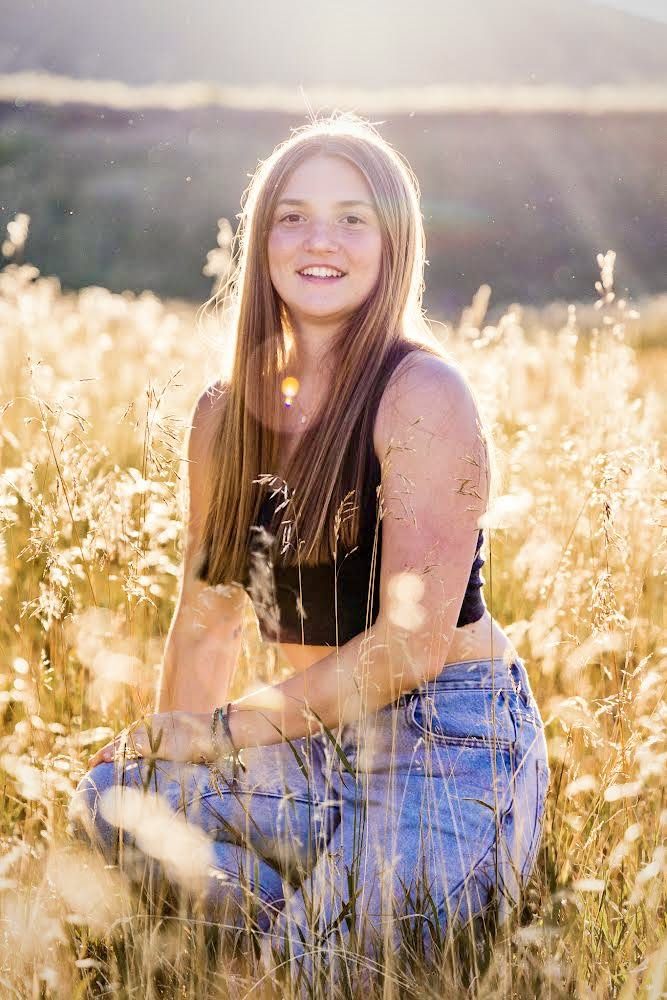 Colorado senior portrait in a golden backlit field