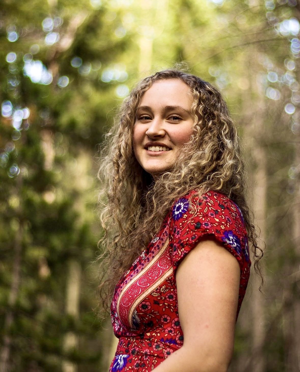 Senior portrait in a red floral dress in the Colorado pines