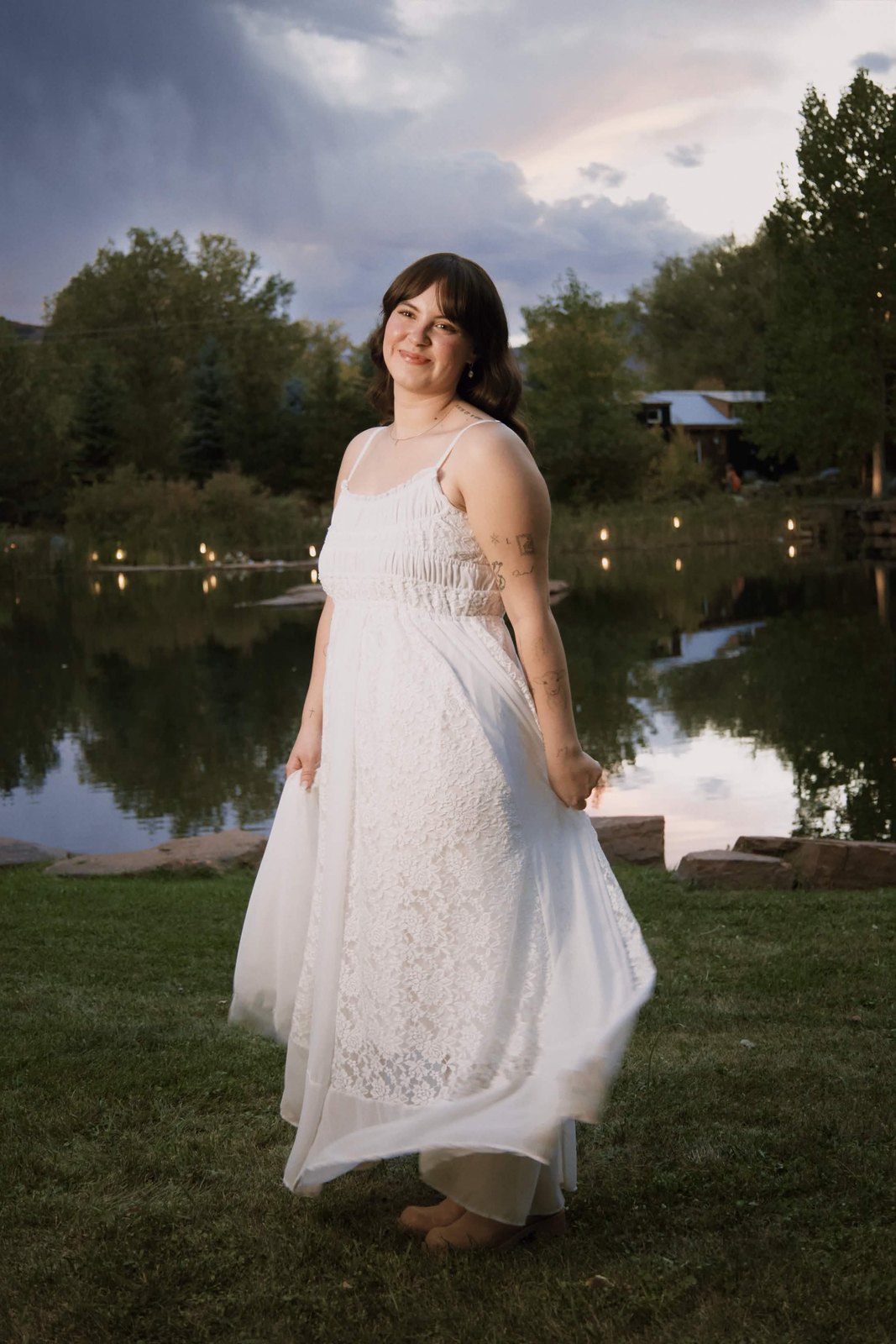 Portrait in a white dress by a pond at dusk