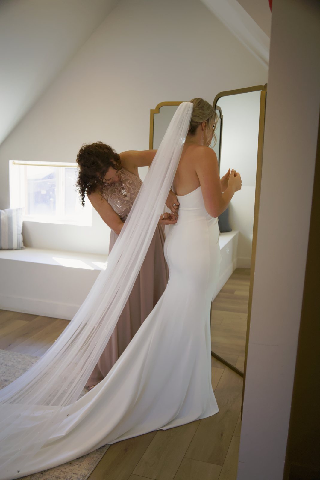 Bridesmaid helping the bride with her veil