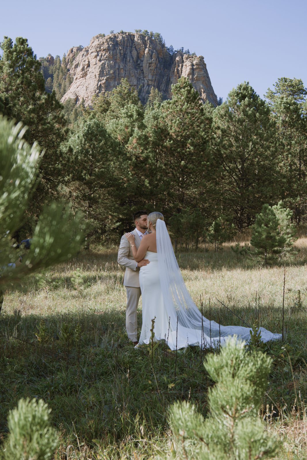 Bride and groom in a meadow below a granite peak