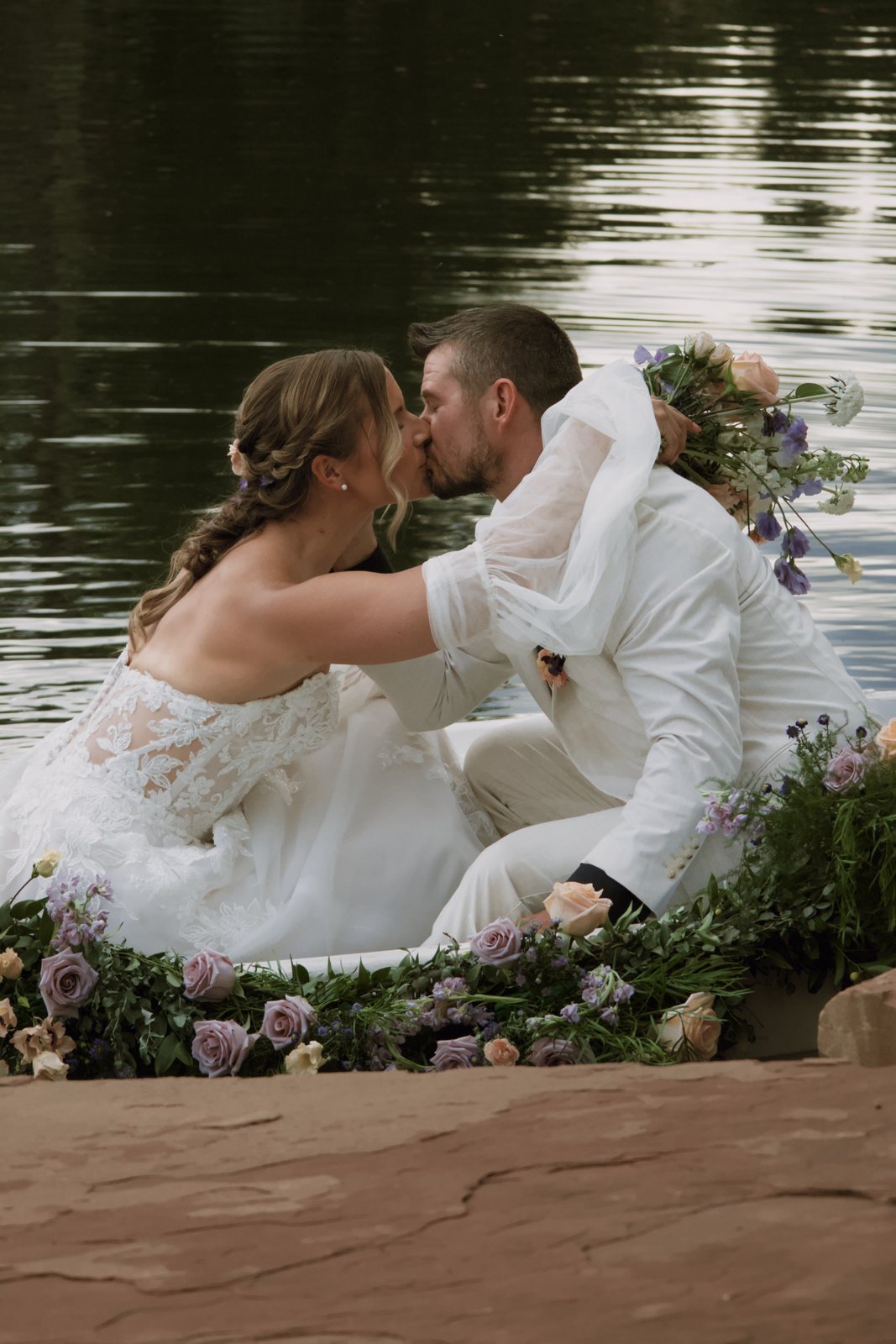 Couple kissing in a flower-covered rowboat