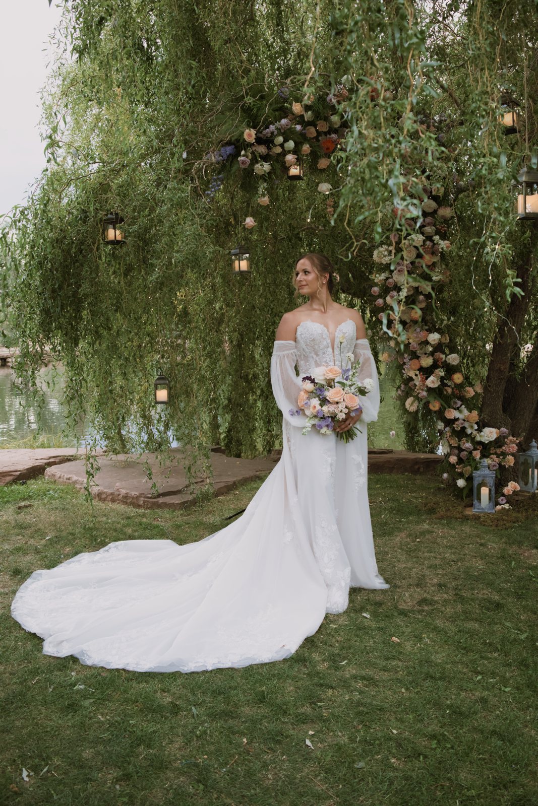 Bride with a long train under a willow arch