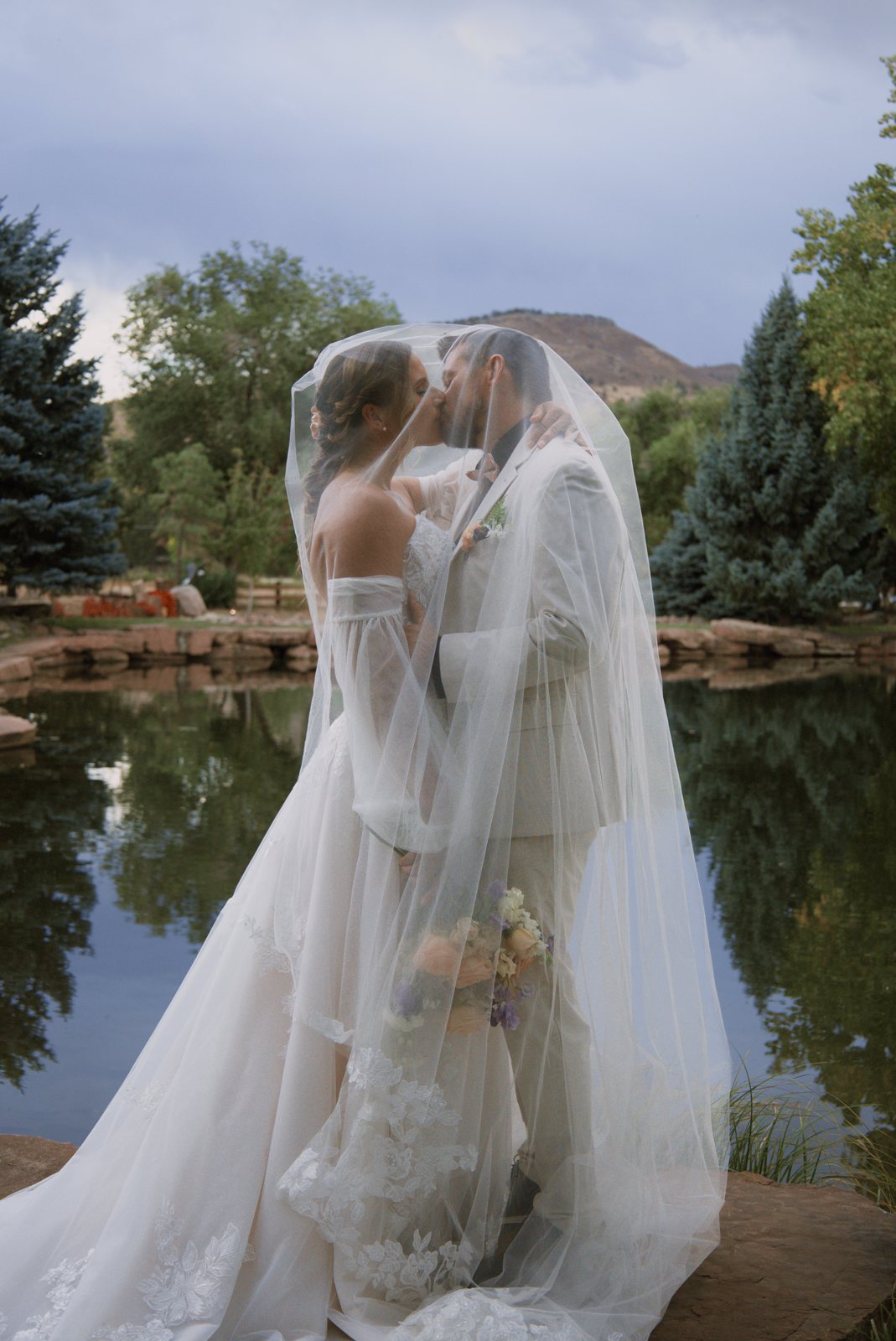 Couple kissing under the veil by a pond